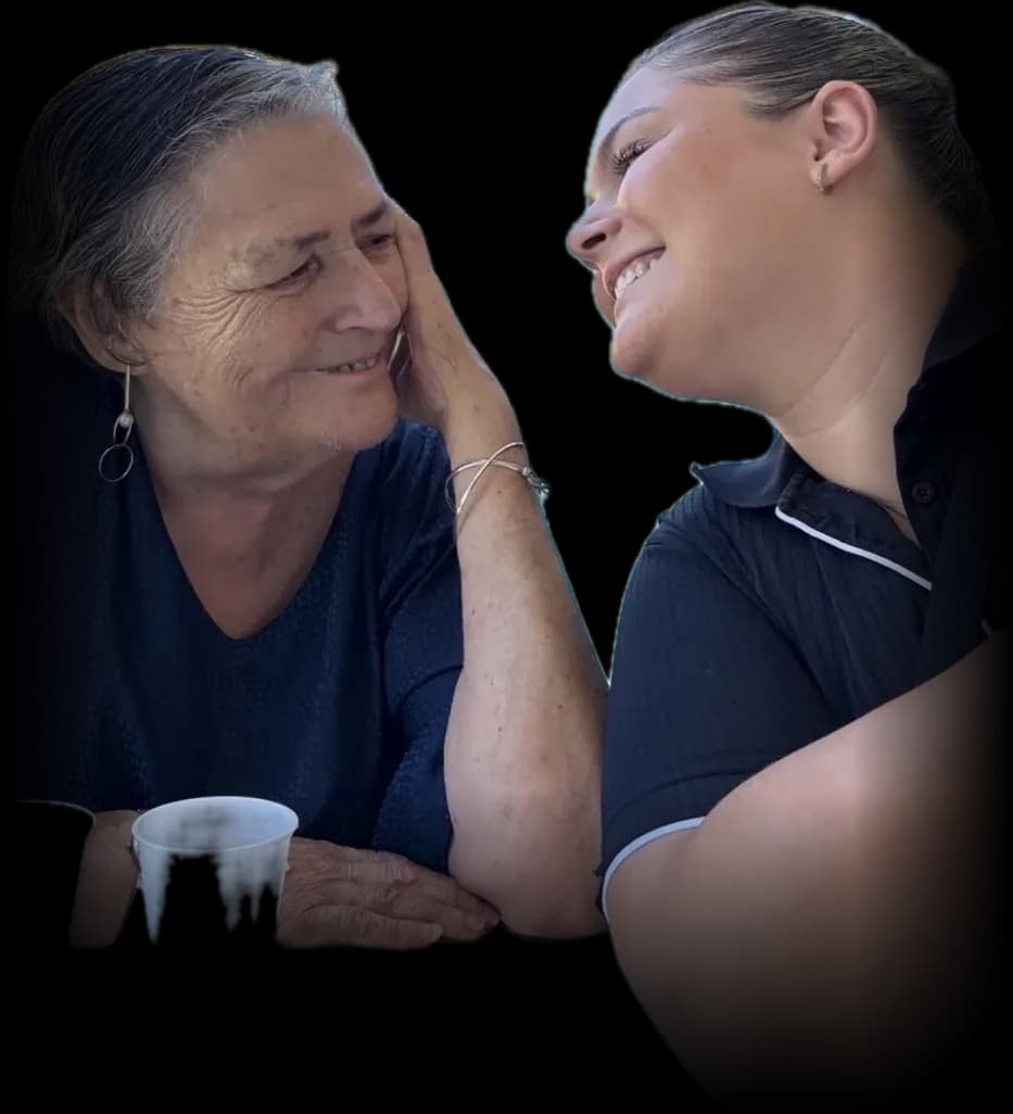 A participant sharing a laugh and a cuppa with her support worker